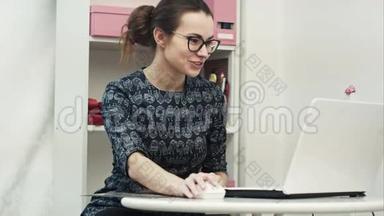 快乐的年轻设计师咨询并提供新衣服给与笔记本电脑进行在线会议的外国客户